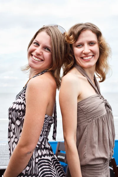 Δύο σέξι γυναίκες συνεργαζόμενα πλάτη με πλάτη. — Φωτογραφία Αρχείου