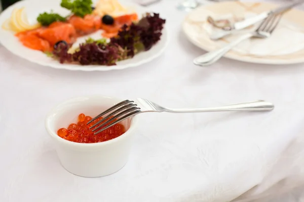Plate with caviar on table, cutlery for dinner, selective focus. — Stock Photo, Image