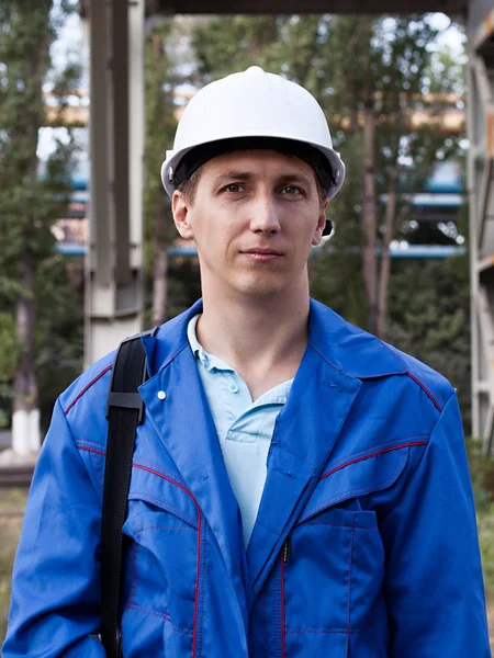 Young handsome man constructor in white hardhat and blue uniform — Stock Photo, Image