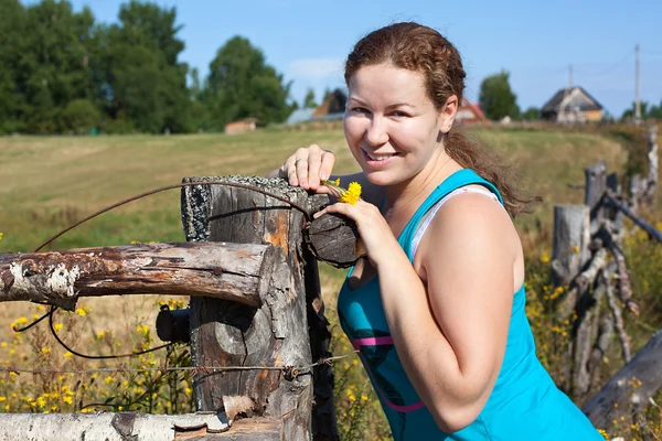 En ung kaukasiska rysk kvinna nära byn staket — Stockfoto