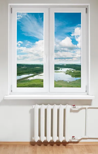 Witte kunststof venster met radiator eronder. — Stockfoto