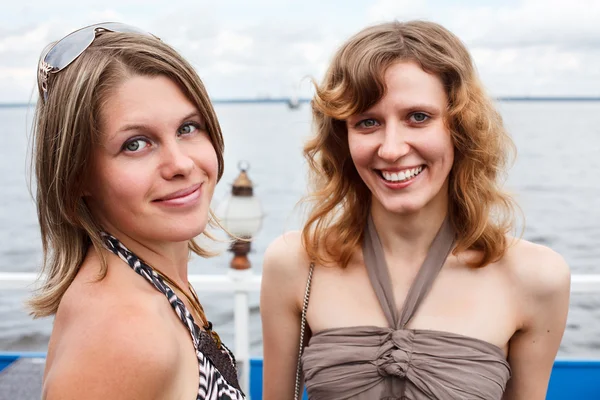 Две красивые молодые женщины стоят вместе и улыбаются — стоковое фото