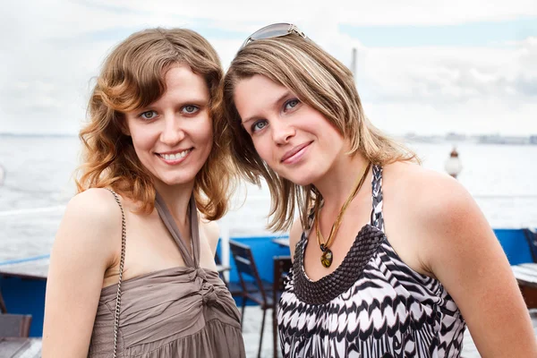 Zwei schöne junge Frauen, die zusammen stehen und lächeln — Stockfoto