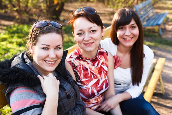 Portrait of three happy friends with a women smiling — Stock Photo, Image