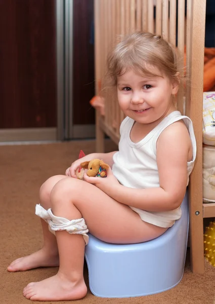 Little girl sitting on a chamber pot — Stock Photo, Image