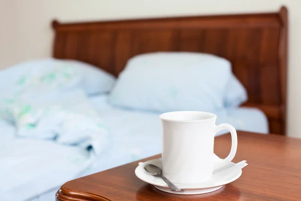 Vit kopp på en säng Nattduksbord — Stockfoto