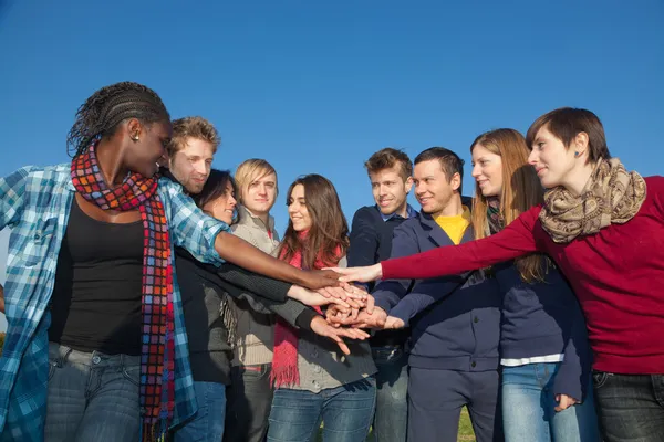 Счастливые студенты колледжа с руками на стеке — стоковое фото