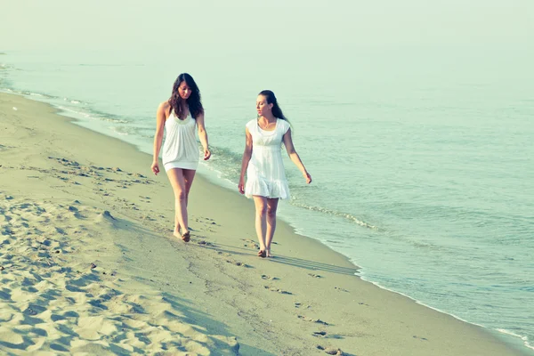 Amici femminili a piedi insieme in riva al mare — Foto Stock