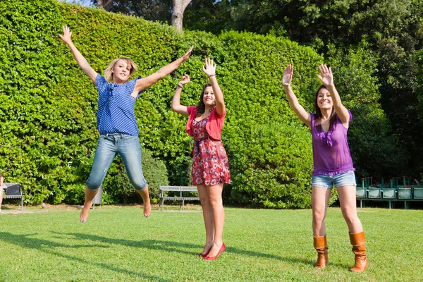 Mutlu genç bayan arkadaşlar atlama — Stok fotoğraf