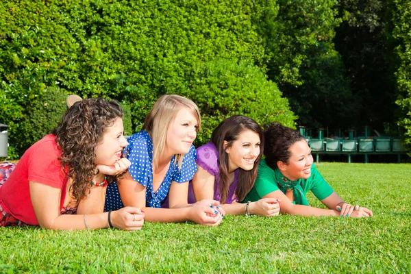 Друзья-подростки, лежащие на зелени в парке — стоковое фото