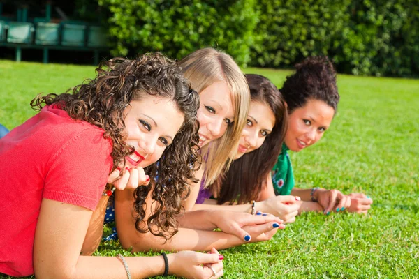 Dospívající kamarádky leží na zelené v parku — Stock fotografie
