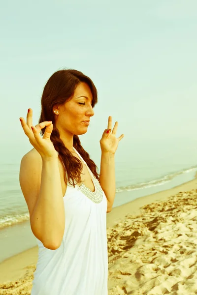 Schöne junge Frau macht Yoga-Übungen am Meer — Stockfoto