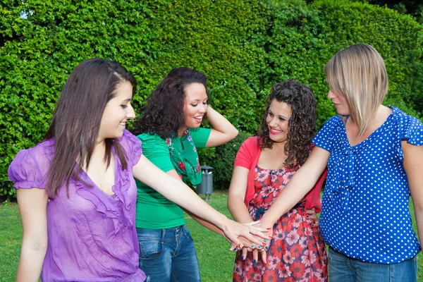 Tiener vriendinnen met hand in stapel — Stockfoto