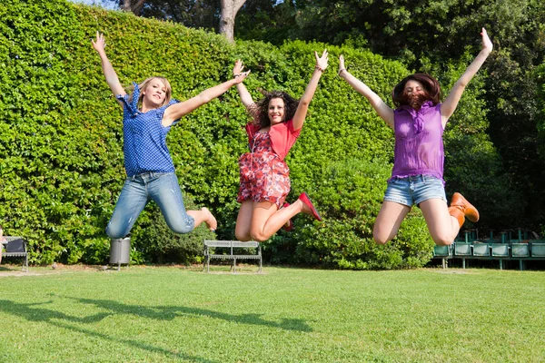 Gelukkig vrouwelijke jeugdvrienden springen — Stockfoto