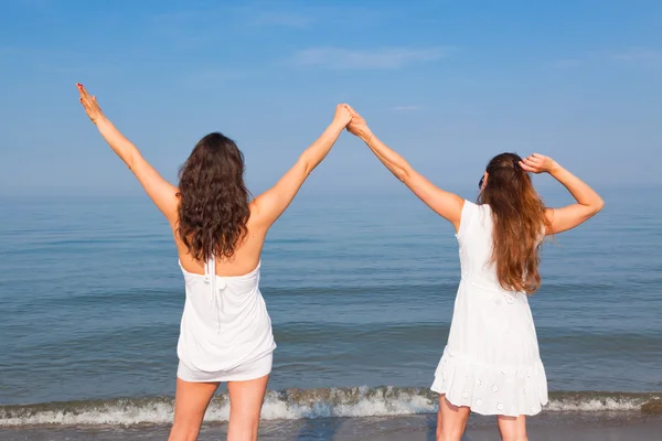 两名年轻妇女在海边上伸胳膊 — 图库照片