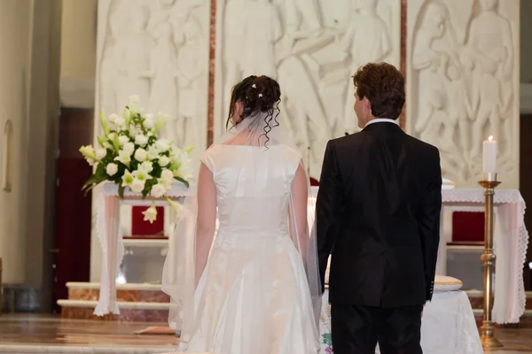 Bruden och brudgummen framför altaret — Stockfoto