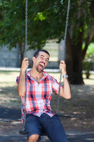 Młody człowiek zabawy na swing — Zdjęcie stockowe
