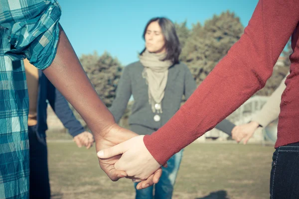 Multiracial jeune tenant les mains dans un cercle — Photo
