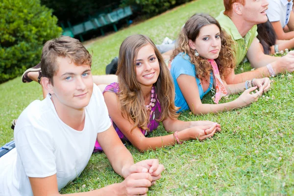 Grupo de adolescentes acostados en el suelo en el parque —  Fotos de Stock