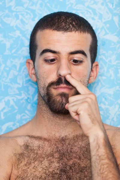 Jonge man het oppakken van zijn neus — Stockfoto
