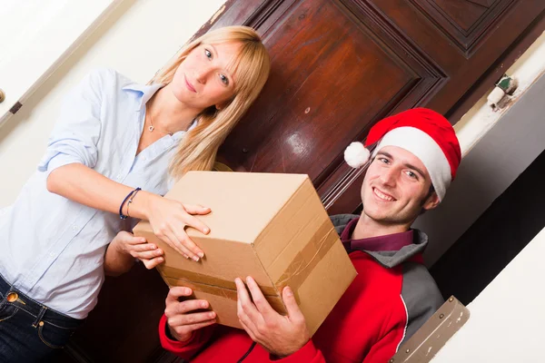 Garçon de livraison avec chapeau et boîte de Noël pour jeune femme — Photo