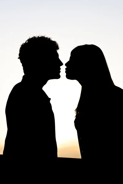日没時の若いカップルのシルエット — ストック写真