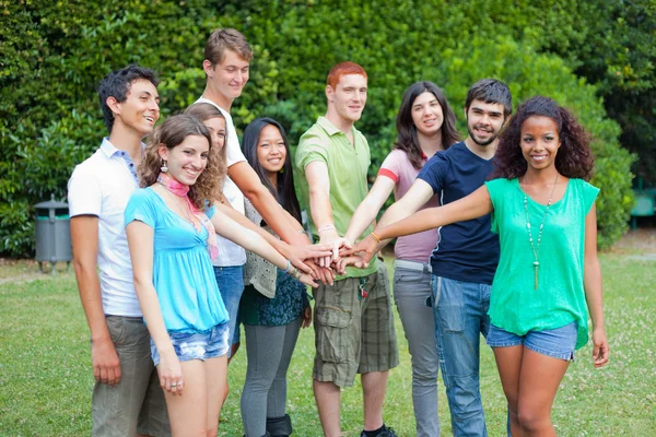 Щаслива група підлітків з руками на стек — стокове фото
