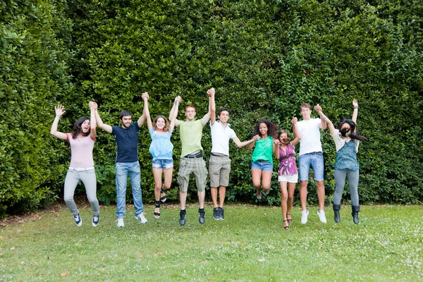 Heureux étudiants du collège d'adolescence sautant au parc — Photo
