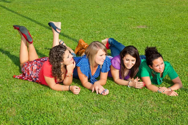 Друзья-подростки, лежащие на зелени в парке — стоковое фото