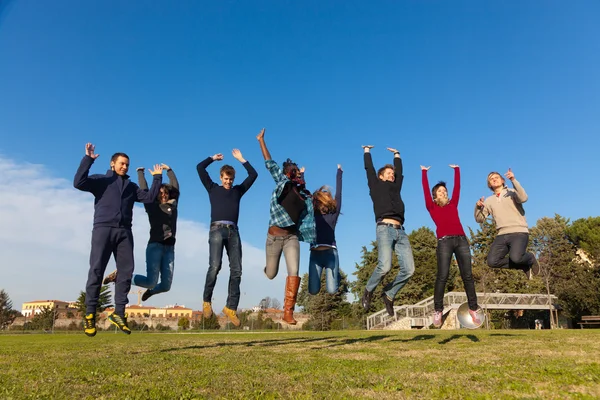 Grupa studentów szczęśliwy, skoki w parku — Zdjęcie stockowe