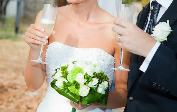 Bruden och brudgummen dricker en skål — Stockfoto