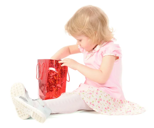 Little girl looking in gift bag — Stok fotoğraf