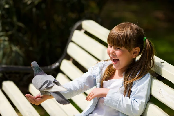 Девочка, кормящая голубей — стоковое фото