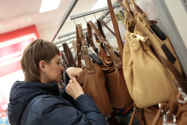 Woman chooses purse in store — Stock Photo, Image