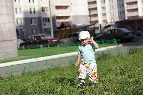 Pojken går på gräsmattan — Stockfoto