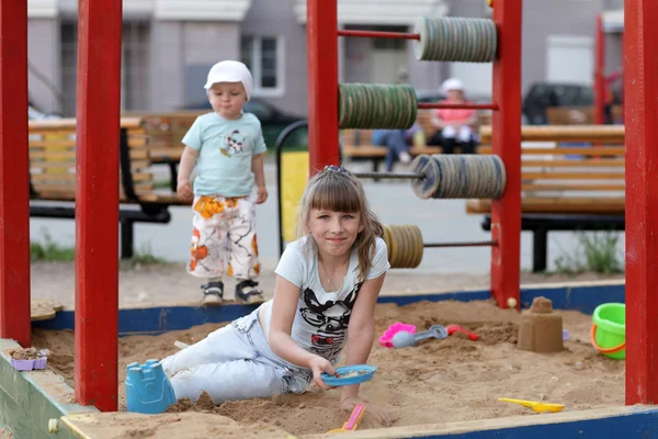 Девушка играет в песочнице — стоковое фото