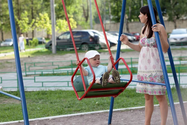 Mother swings her child — Stock Photo, Image