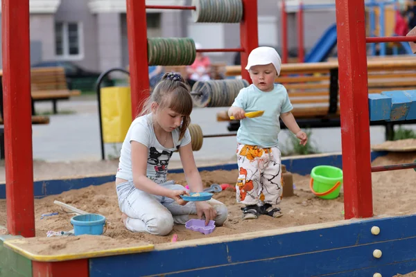 Siblings play in sandbox — Stock Photo, Image