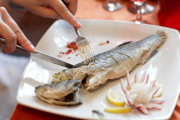 Woman cuts dorado fish — Stock Photo, Image