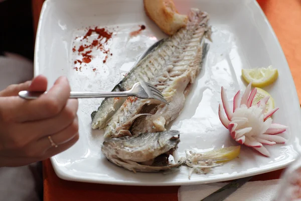 Woman eats dorado fish — Stock Photo, Image