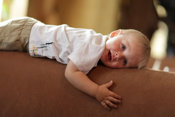 Ребёнок лежит на спинке дивана — стоковое фото