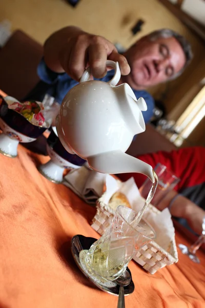 El hombre vierte té en la cafetería —  Fotos de Stock