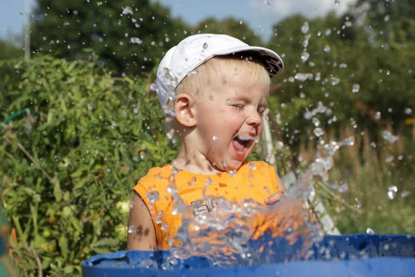 Счастливый мальчик и брызги воды — стоковое фото