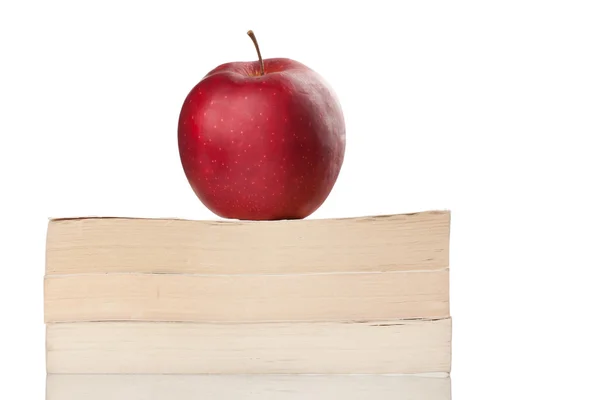 Красное яблоко на книге, изолированной на белом — стоковое фото