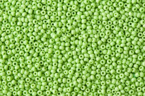 Bakgrund av gröna pärlor på nära håll — Stockfoto