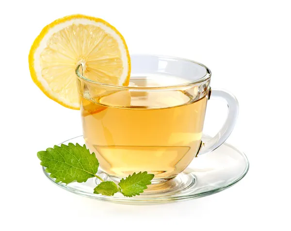 ガラスのレモンとお茶のカップとミントの葉 — ストック写真
