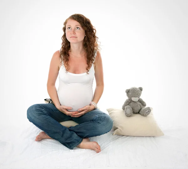 Junge schwangere Frau sitzt mit Bär — Stockfoto