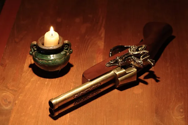 Старинный пистолет и свеча — стоковое фото