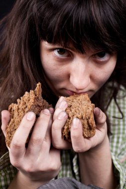 Beggar woman with a piece of bread in her hands clipart