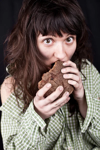 Mujer mendiga comiendo pan — Foto de Stock